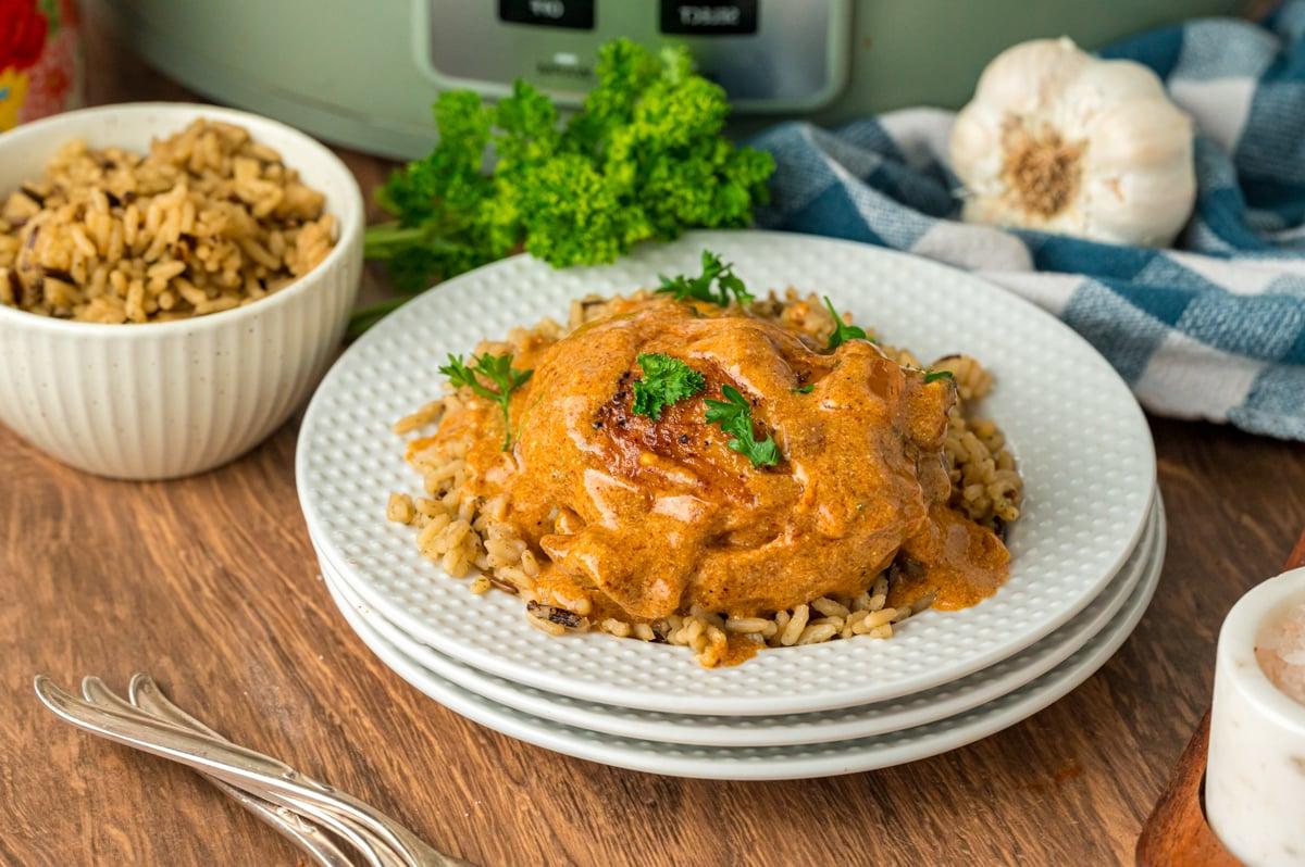 Pollo alla Paprica in Cottura Lenta 8 Porzione di pollo alla paprika in slow cooker su un letto di riso con salsa sopra.