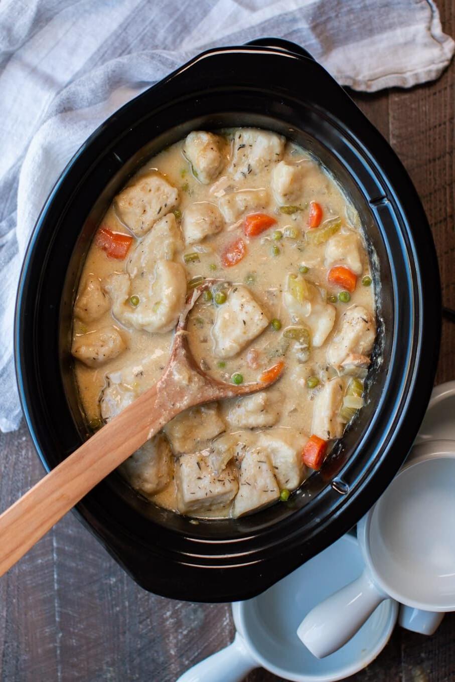 **Pollo e Gnocchi in Pentola a Cottura Lenta {con biscotti in scatola}** 8 Gnocchi di pollo cotti nella slow cooker con un cucchiaio all'interno.