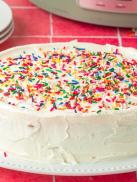 Torta di compleanno cotta nella slow cooker su un piatto bianco.