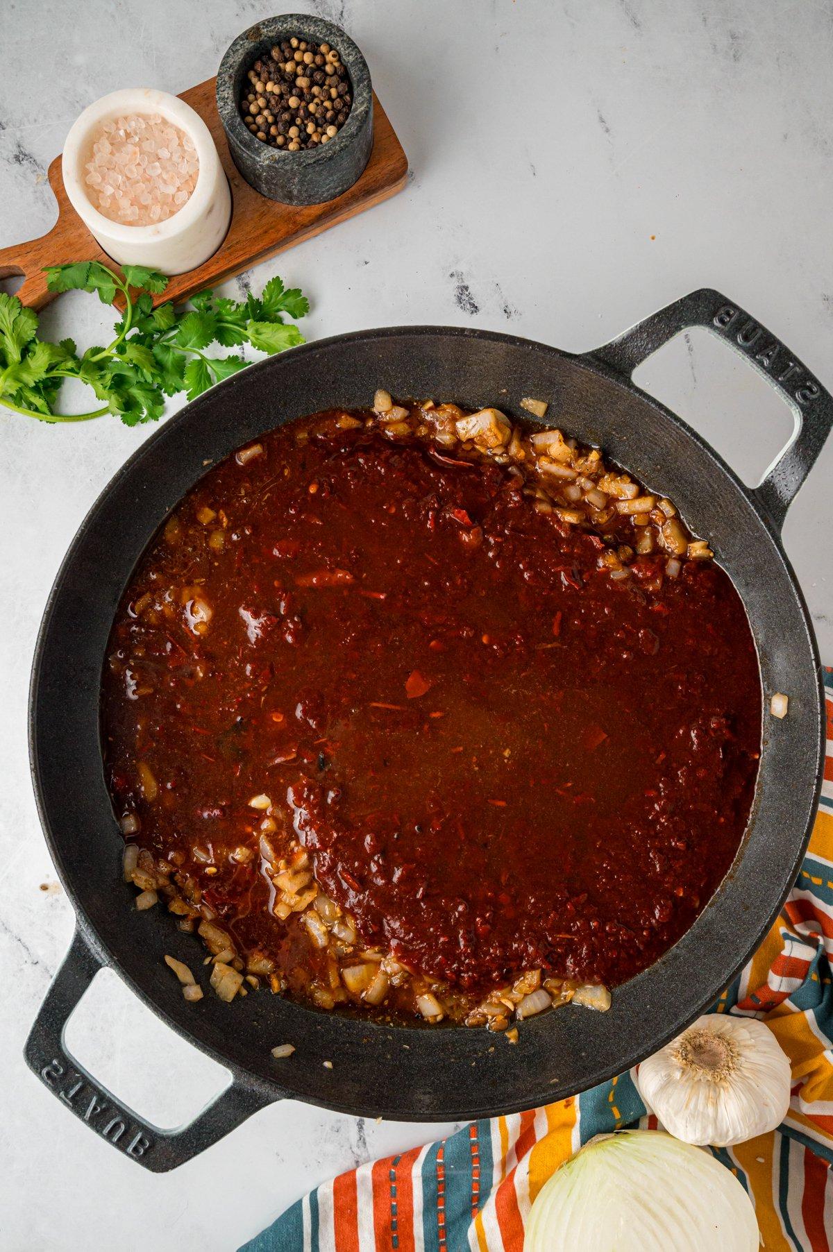 Cipolla, aglio, miscela di peperoncino e condimenti in una padella.