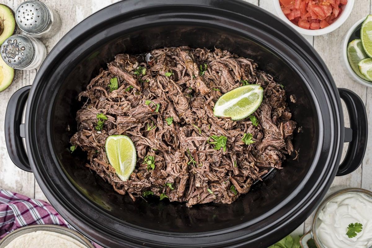 Manzo Sfilacciato Messicano a Cottura Lenta 9 Manzo sfilacciato messicano nel slow cooker con 2 lime sopra