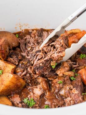 **Stracotto all'Italiana** 9 pinze che prendono del manzo brasato all'italiana in slow cooker.