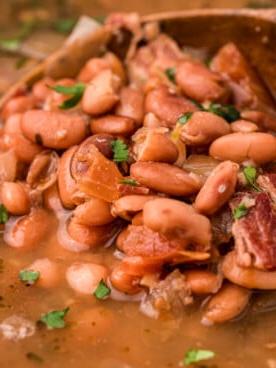 Fagioli Charro alla Cottura Lenta 10 Primo piano di un fagiolo charro su un cucchiaio di legno.