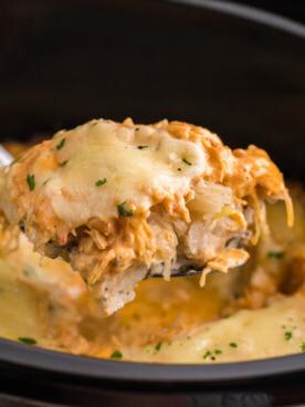 Casseruola di Pollo alla Reuben a Cottura Lenta 10 Cucchiaio con sformato di pollo Reuben in slow cooker sopra una pentola a cottura lenta.