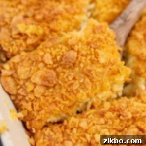 Ultimate Breakfast Hash Brown Bake 9 Lifting a square of hash brown casserole from a baking dish.