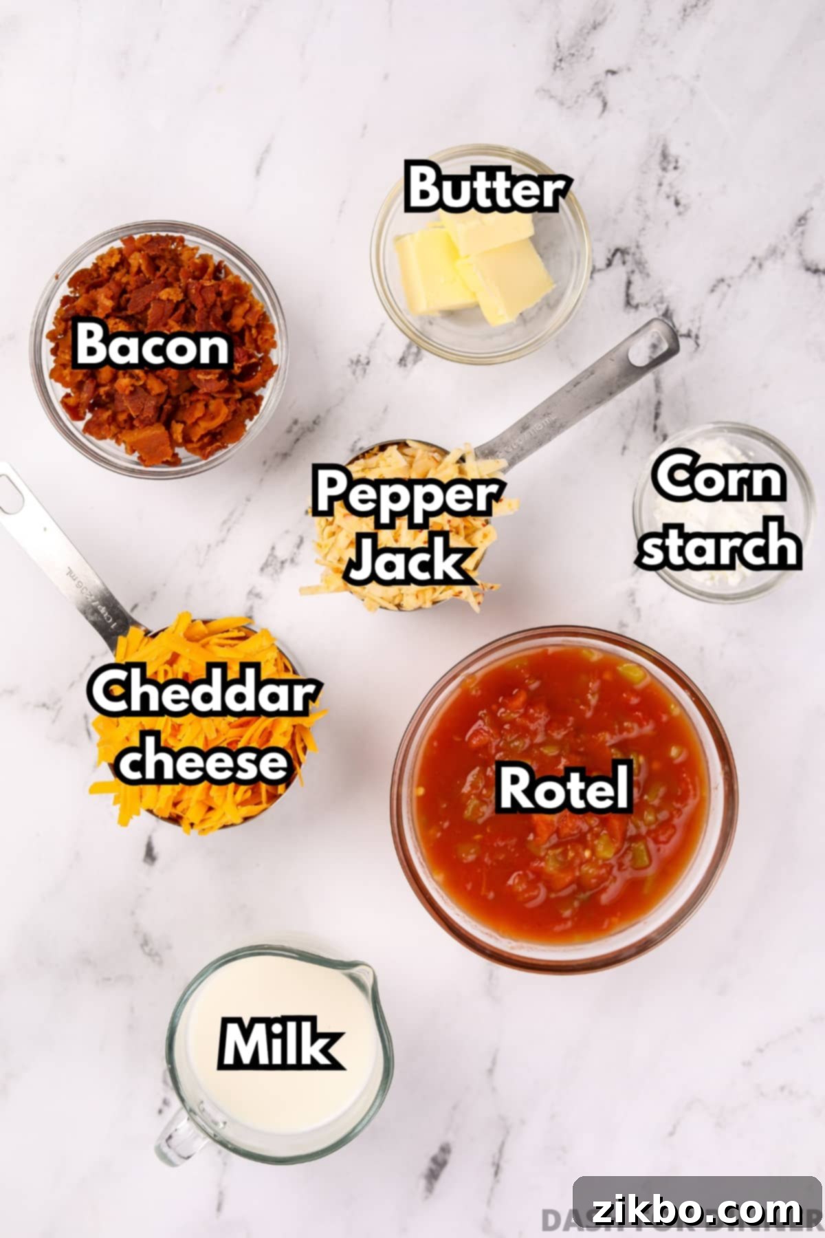 An overhead image of the ingredients needed to make nacho cheese dip, including shredded cheeses, rotel, milk, butter, cornstarch, and crumbled bacon.