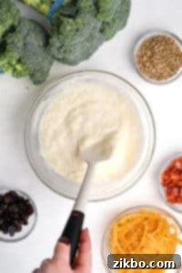 Stirring together a creamy dressing with a silicone spatula for the broccoli salad recipe.