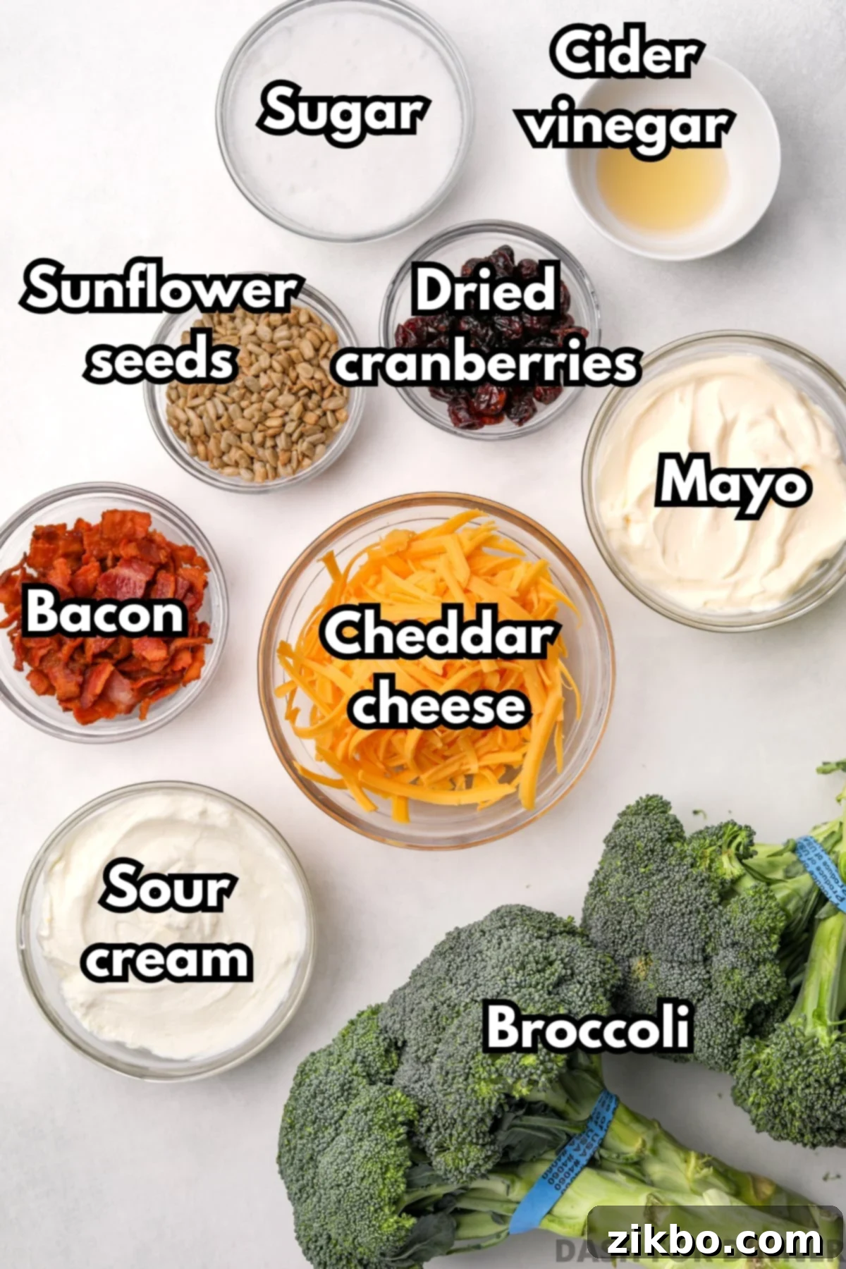 Crunchy Broccoli Delight 3 The ingredients needed to make broccoli salad, including fresh broccoli, sharp cheddar cheese, crispy bacon, sour cream, and mayonnaise.