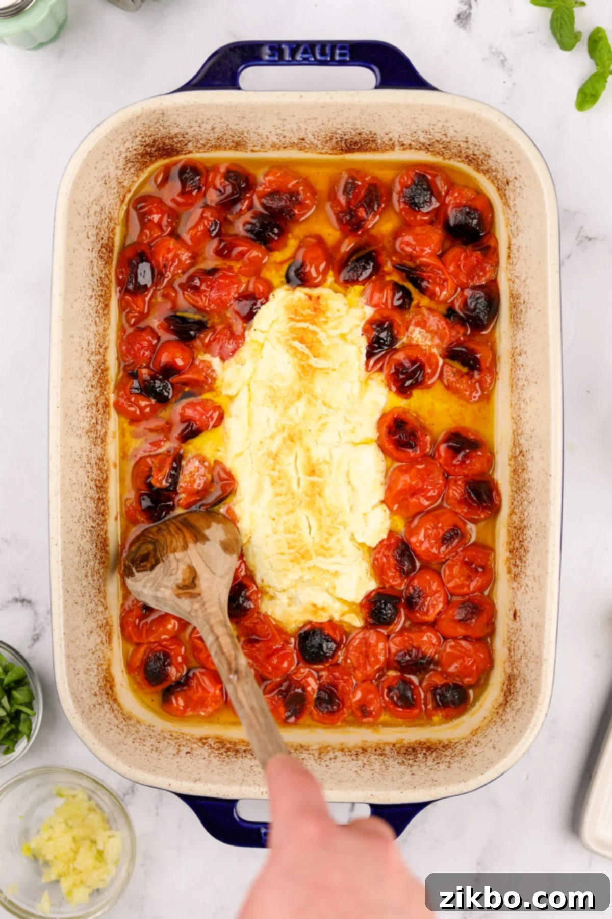 Tangy Goat Cheese Pasta Bake 2 A baking dish filled with roasted cherry tomatoes and goat cheese, ready to be mixed into a creamy pasta sauce.