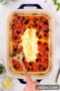 A baking dish filled with roasted cherry tomatoes and goat cheese.