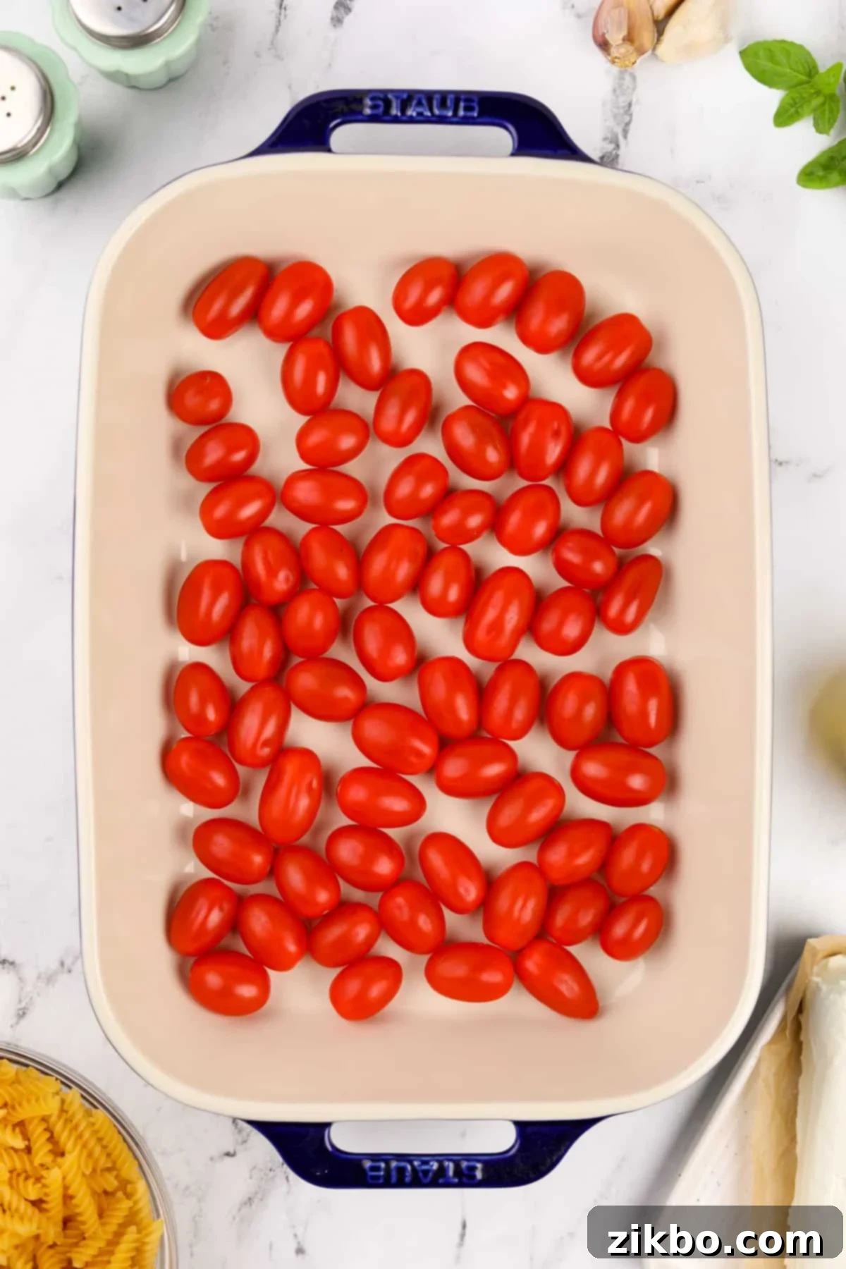 Tangy Goat Cheese Pasta Bake 4 Cherry tomatoes evenly spread in a large baking dish.