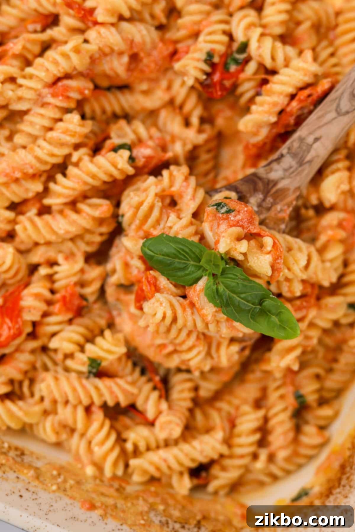 Tangy Goat Cheese Pasta Bake 10 A close-up of the creamy baked goat cheese pasta sauce, garnished with fresh basil leaves.