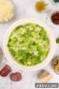 A large bowl of mixed romaine and iceberg lettuce, finely chopped.