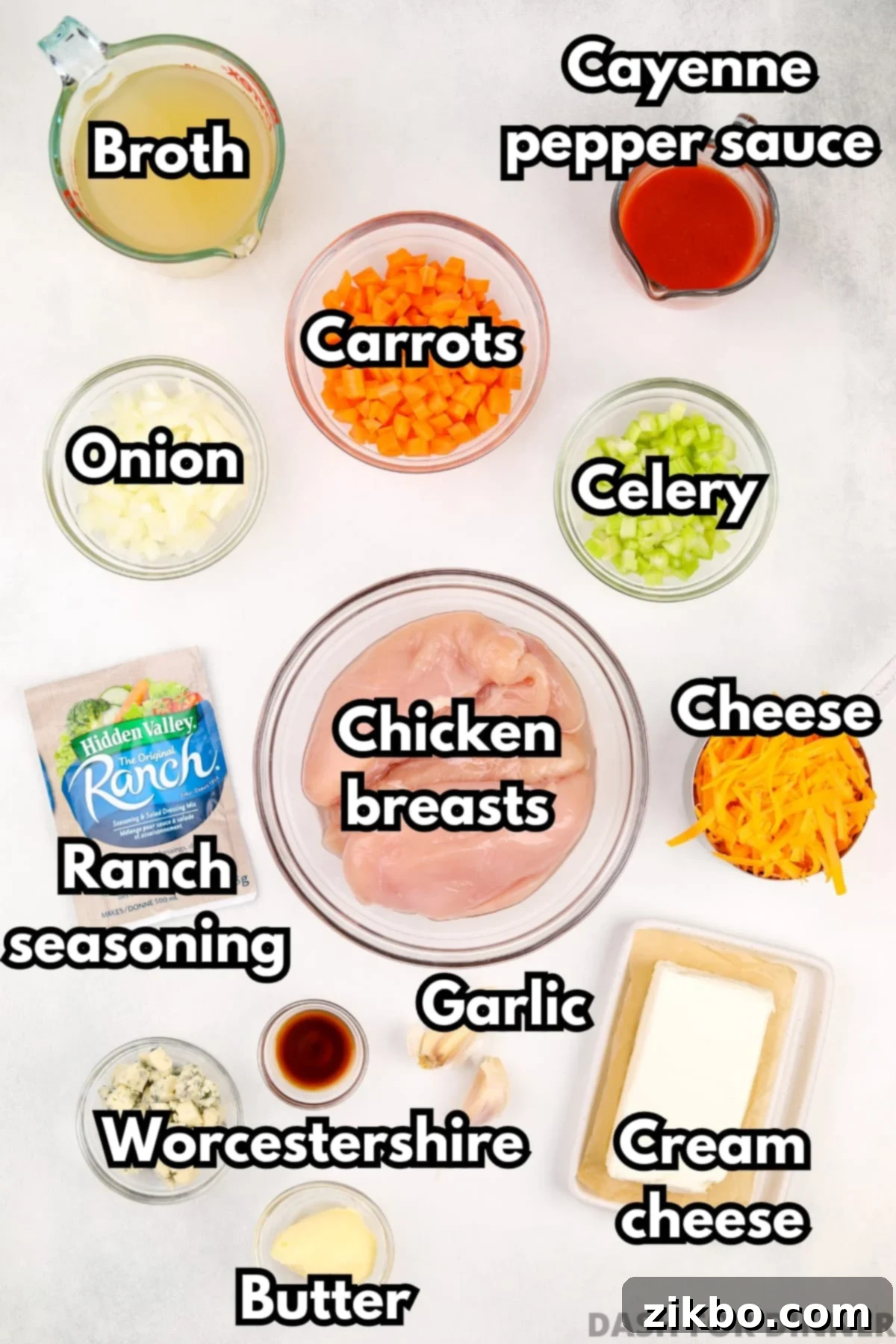 Bold Buffalo Chicken Soup 3 A selection of fresh ingredients including chicken breasts, cream cheese, celery, onion, carrots, broth, and hot sauce, laid out for making spicy chicken soup.