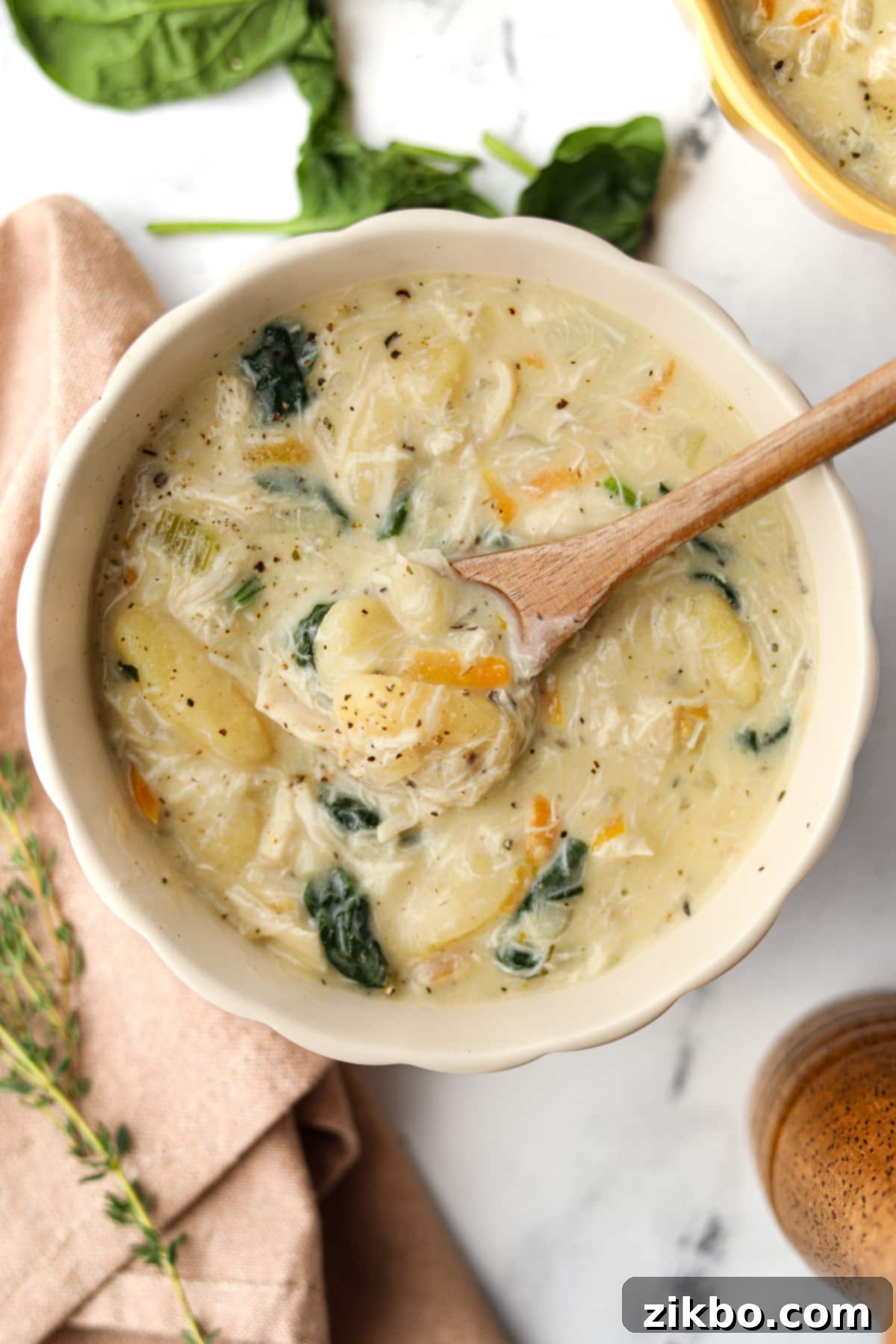 Comforting Creamy Chicken Gnocchi Soup 6 A cozy bowl of chicken gnocchi soup with a small wooden spoon, ready to be enjoyed.