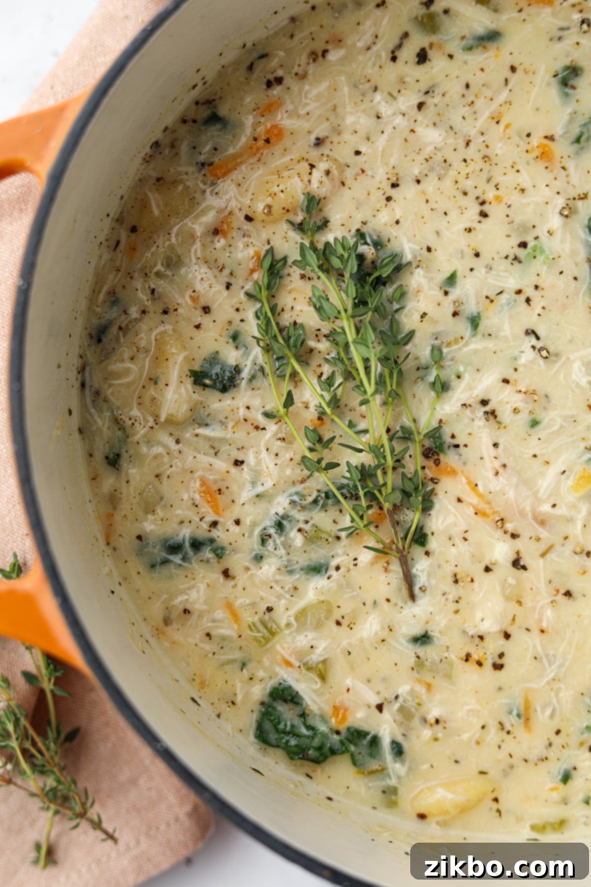 Comforting Creamy Chicken Gnocchi Soup 7 A large Dutch oven filled with creamy chicken gnocchi soup, garnished with fresh thyme twigs, ready to be served.