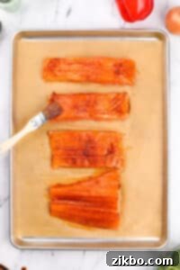 Brushing salmon fillets with a seasoned oil.