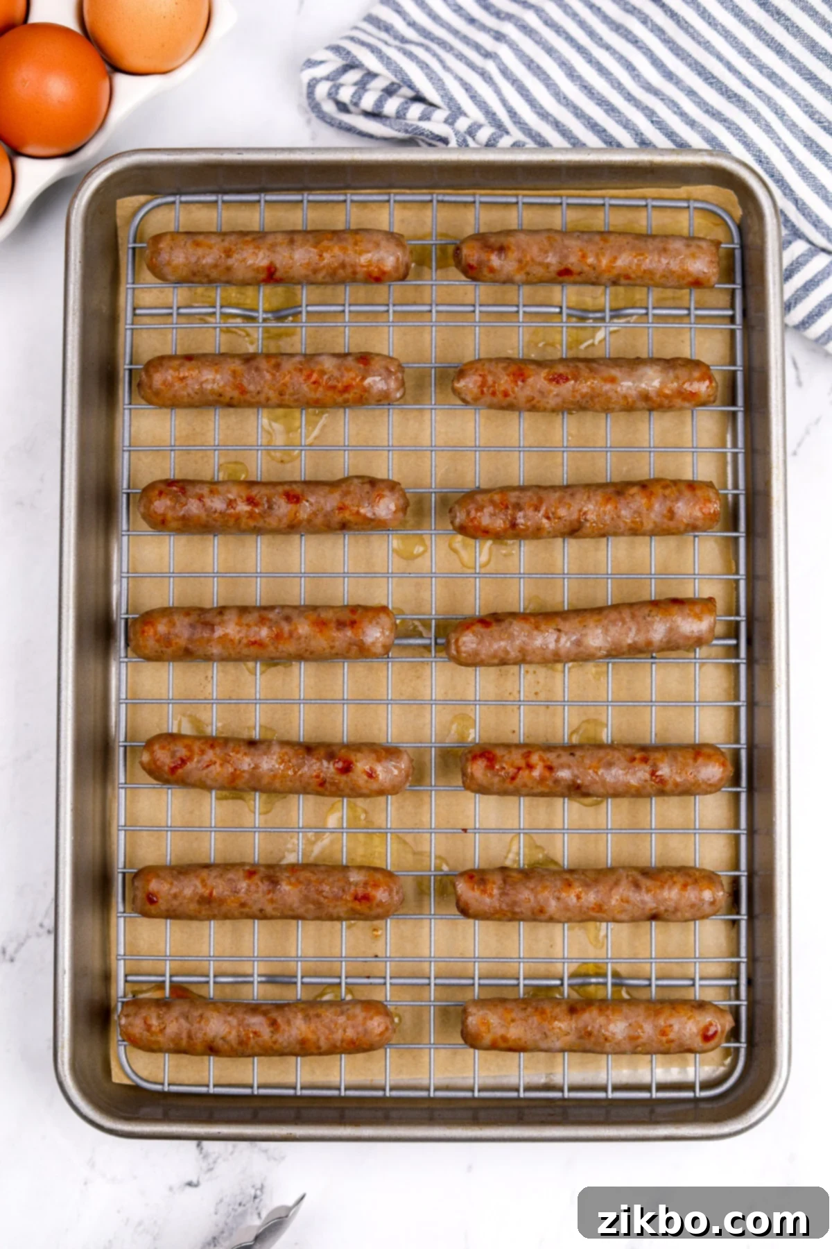 A completed baking sheet with a wire rack full of perfectly cooked and golden-brown breakfast sausage links, fresh from the oven.