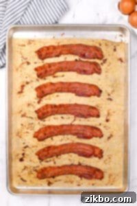 A baking sheet with 8 slices of bacon that have been cooked until crispy.