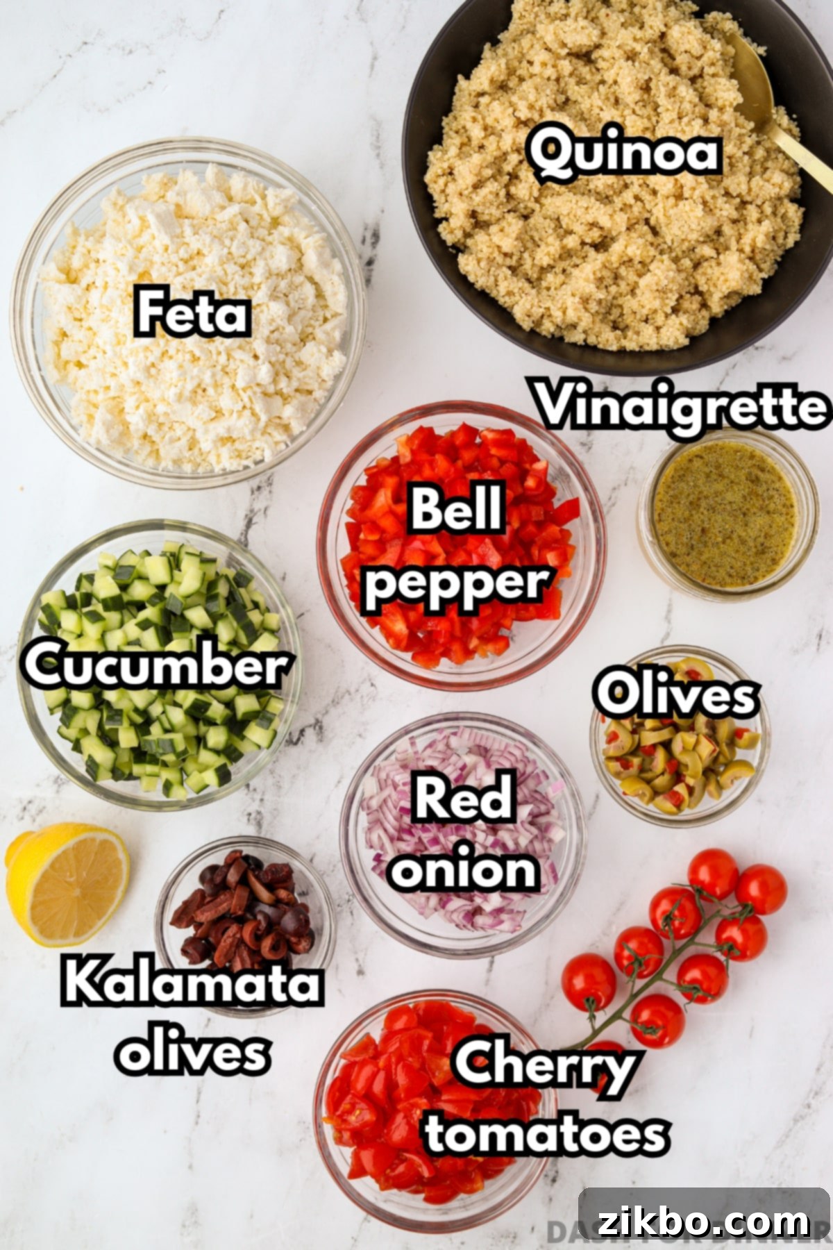 The ingredients needed to make a Greek style quinoa salad, including cucumbers, bell pepper, red onion, and olives.