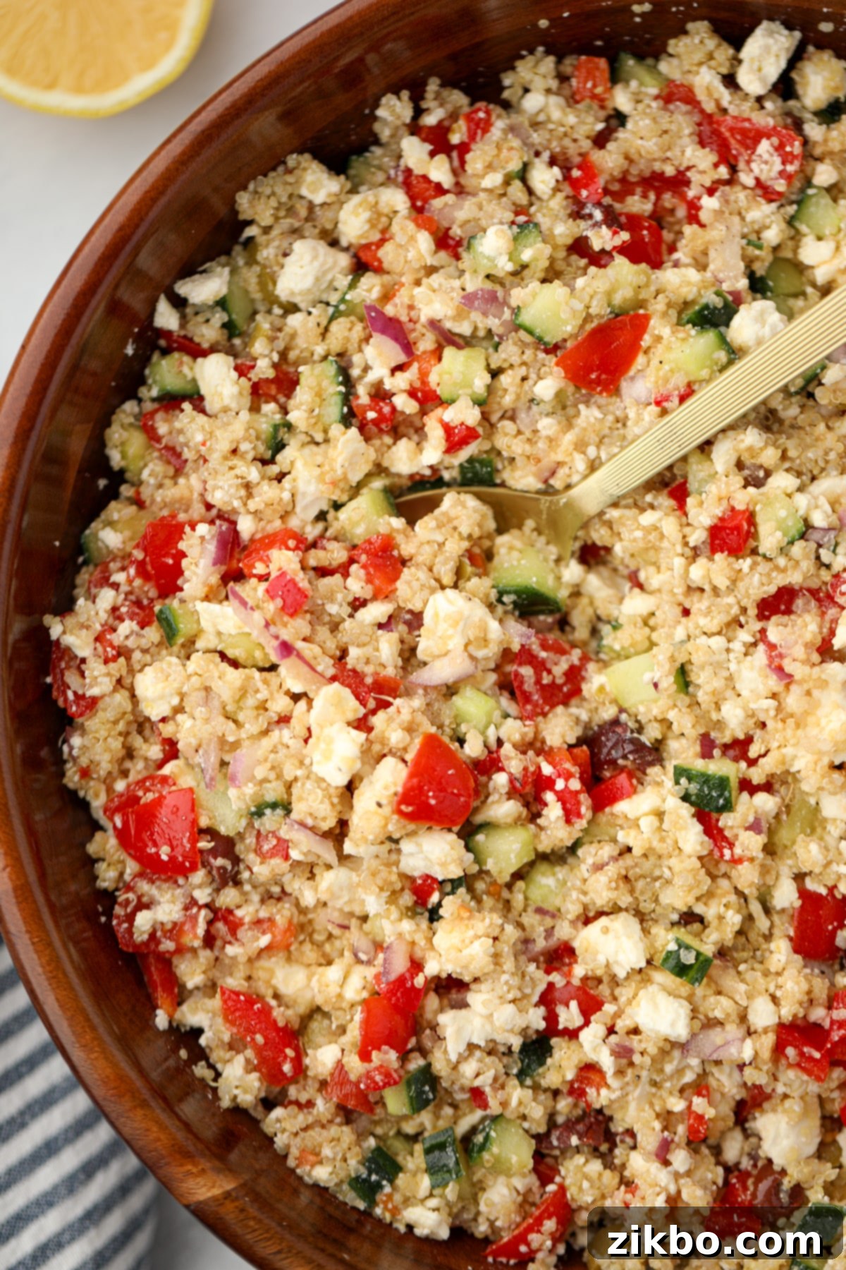 Scooping a portion of quinoa salad from a large salad bowl.