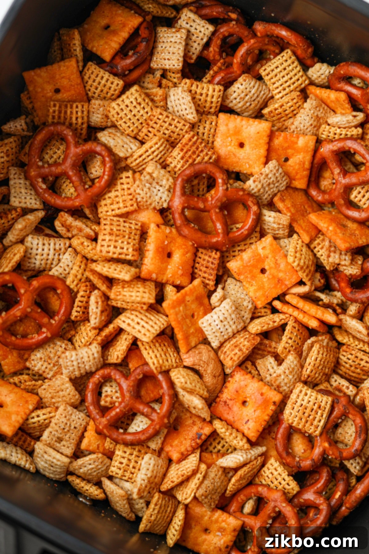 A close up on Chex mix, featuring pretzels, cheez-its, and Chex cereal.
