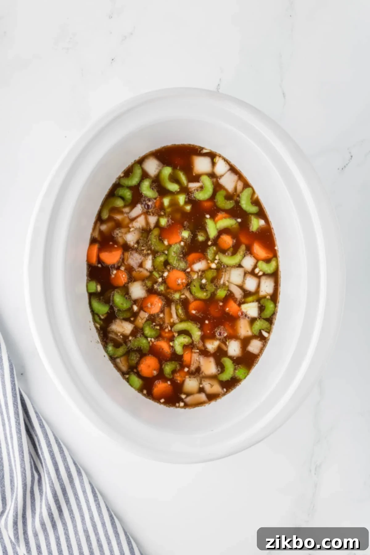 Hearty Slow Cooker Beef Stew with Tender Dumplings 8 A slow cooker with vegetables and beef broth.