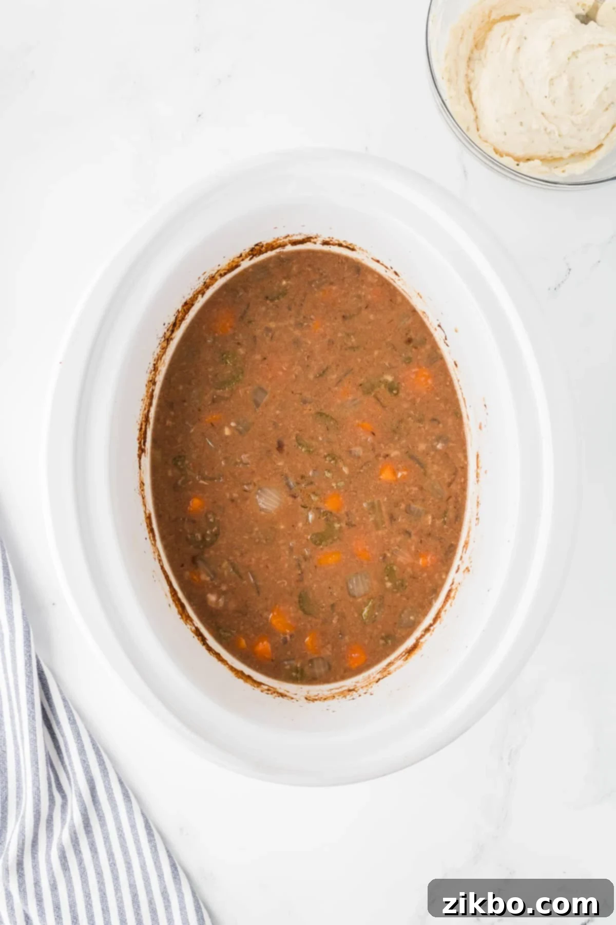 Hearty Slow Cooker Beef Stew with Tender Dumplings 9 A slow cooker filled with cooked beef stew.