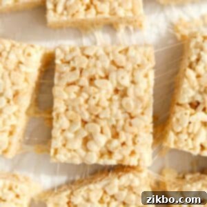 Crispy Sweet Squares 14 A perfectly square Rice Krispie treat with visible crispy cereal and gooey marshmallow, set against a clean white background, ready for a bite.
