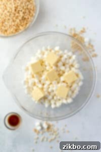 A bowl filled with mini marshmallows and topped with butter.
