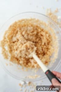 A bowl of rice cereal being mixed with melted marshmallows.