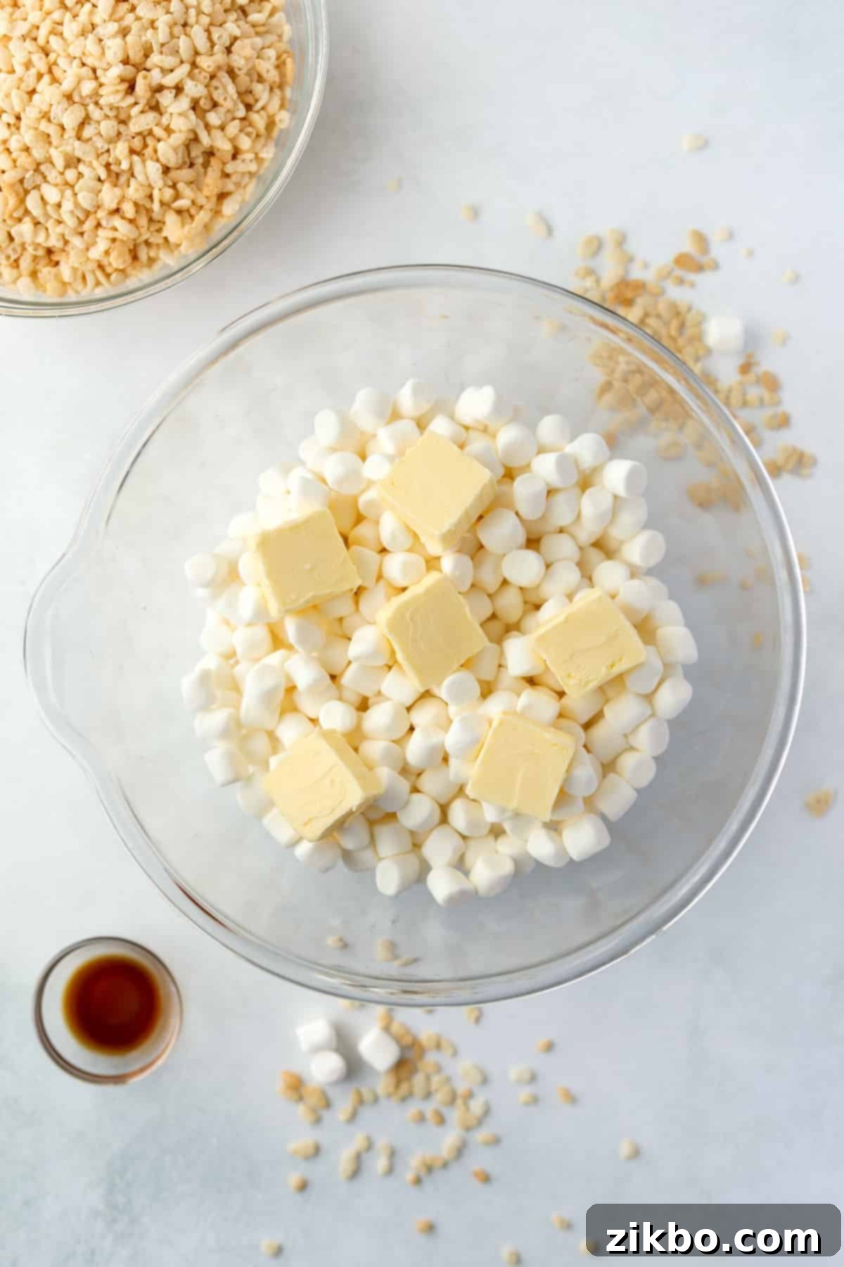 Crispy Sweet Squares 4 A large bowl filled with fluffy mini marshmallows, topped with small cubes of butter, ready for melting.