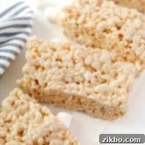 Your Little Krispie Fix 8 Homemade rice krispies treats on a white background with a blue stripe napkin.