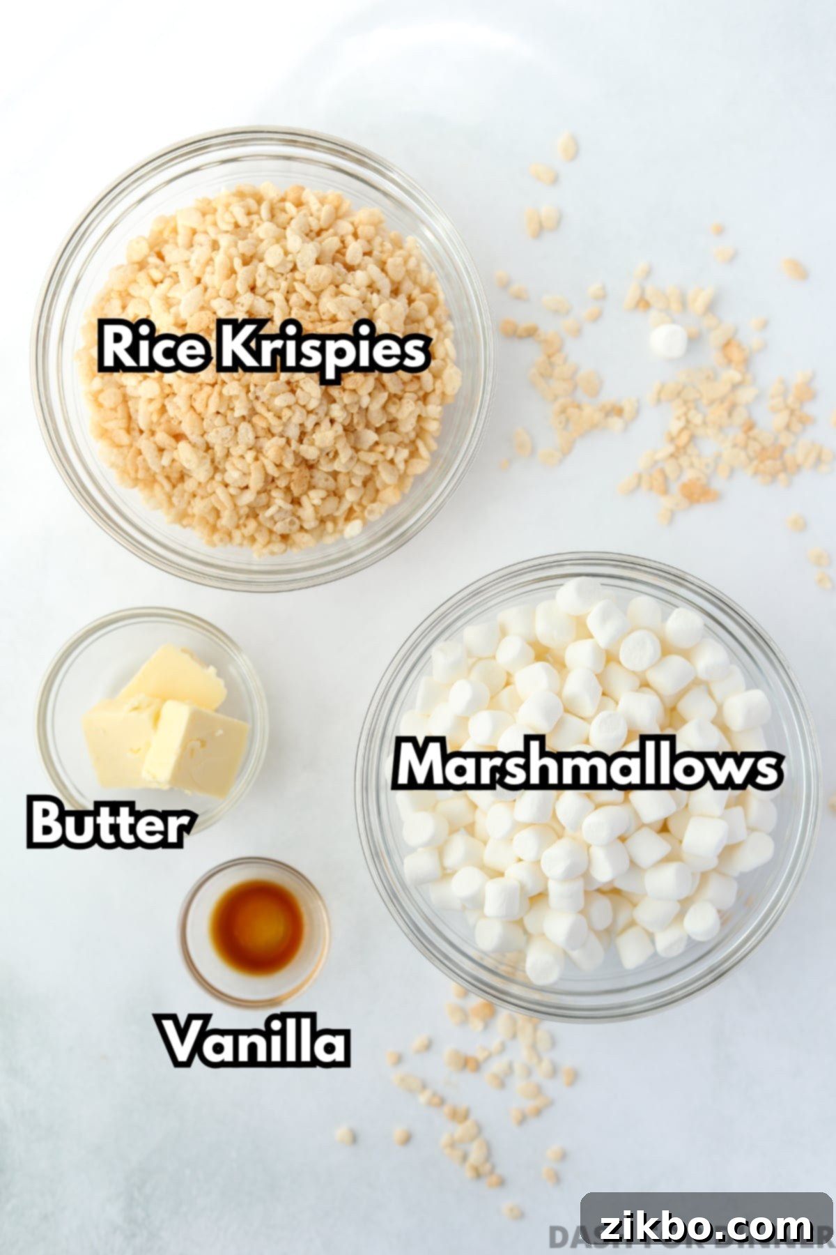 Your Little Krispie Fix 3 A bowl of rice krispies, a bowl of mini marshmallows, and small bowls of butter and vanilla extract.