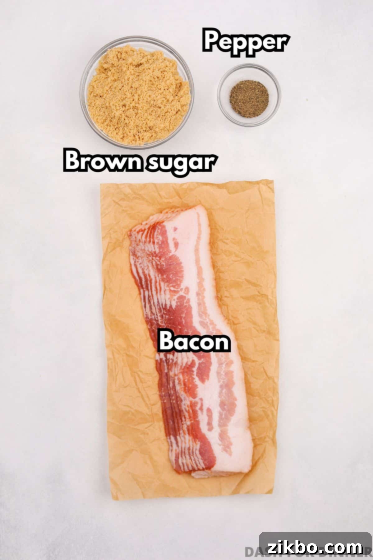 Millionaire's Bacon 3 The three essential ingredients needed to make candied bacon: a bowl of brown sugar, a grinder of black pepper, and a package of raw bacon strips.
