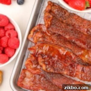 Sweet and Crispy Air Fryer Bacon Bliss 8 A stack of glazed bacon slices piled on top of a wire rack.