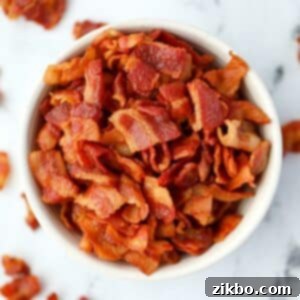A small bowl of bacon bits on a marble counter.