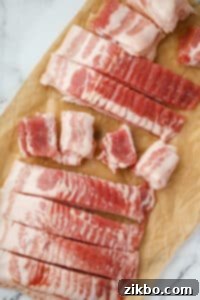 Slicing bacon into cubes.