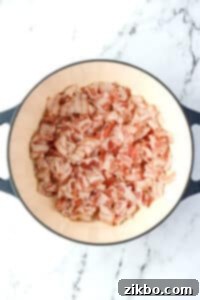 A dutch oven filled with bacon pieces.