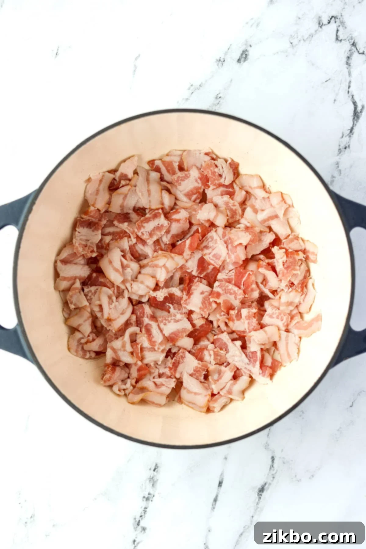 A dutch oven filled with bacon pieces.