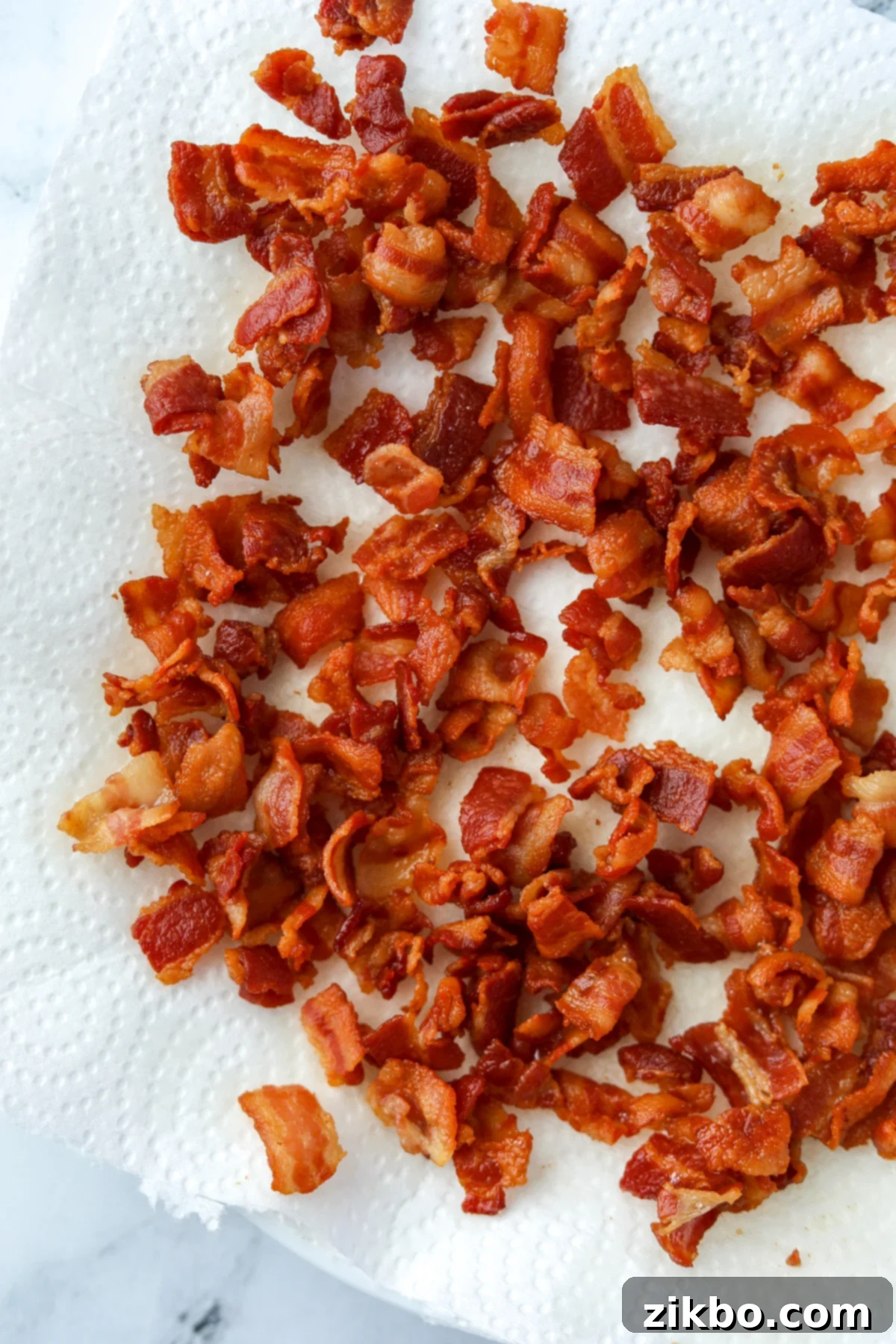Homemade bacon bits draining on a paper towel.
