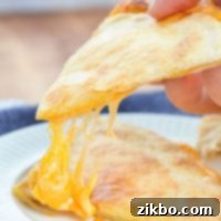 An air fryer quesadilla, with a big stretch of cheese.