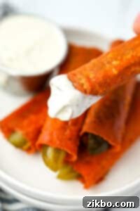 Dipping crispy pickles into ranch dressing.