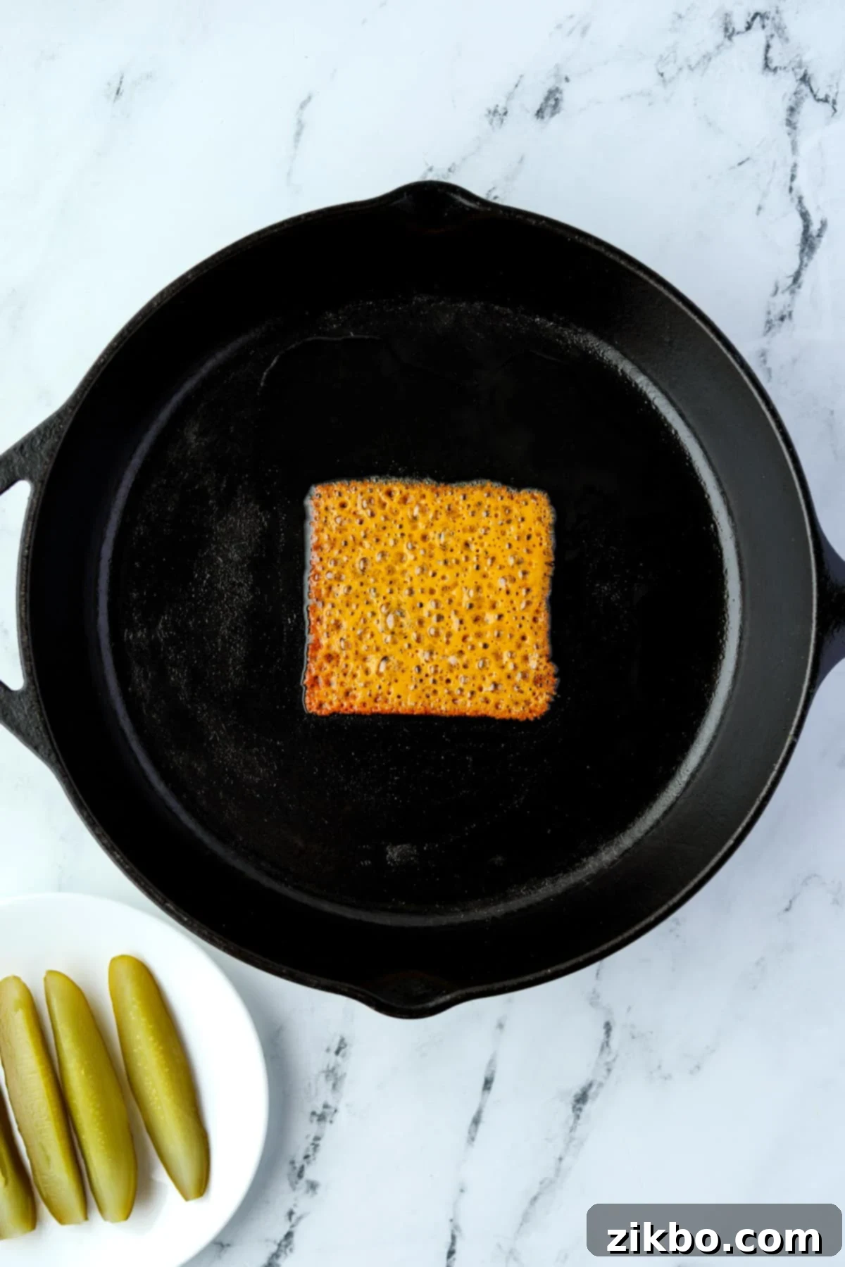 A skillet with a melted cheese slice in the middle.