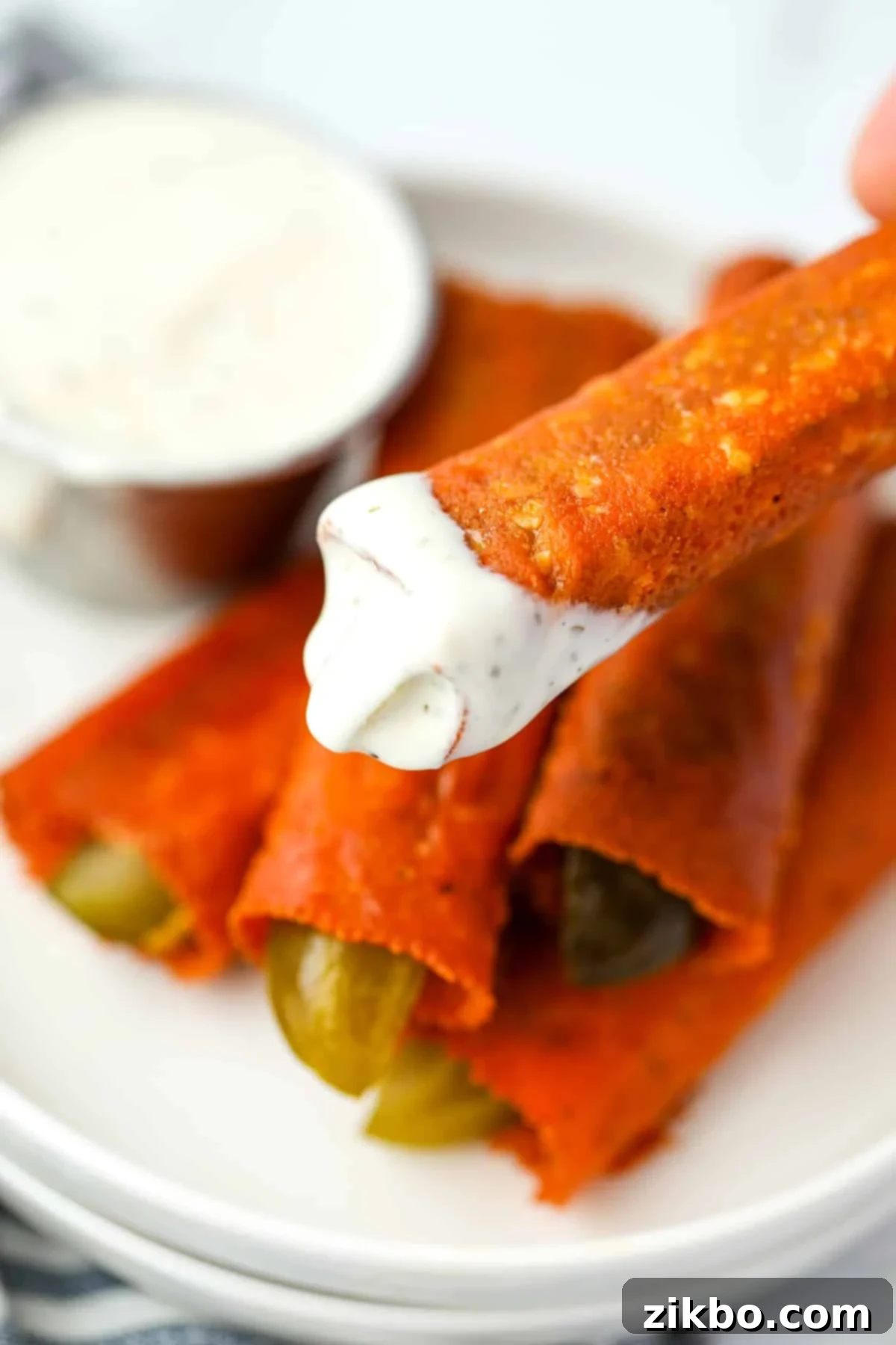 Dipping crispy pickles into ranch dressing.