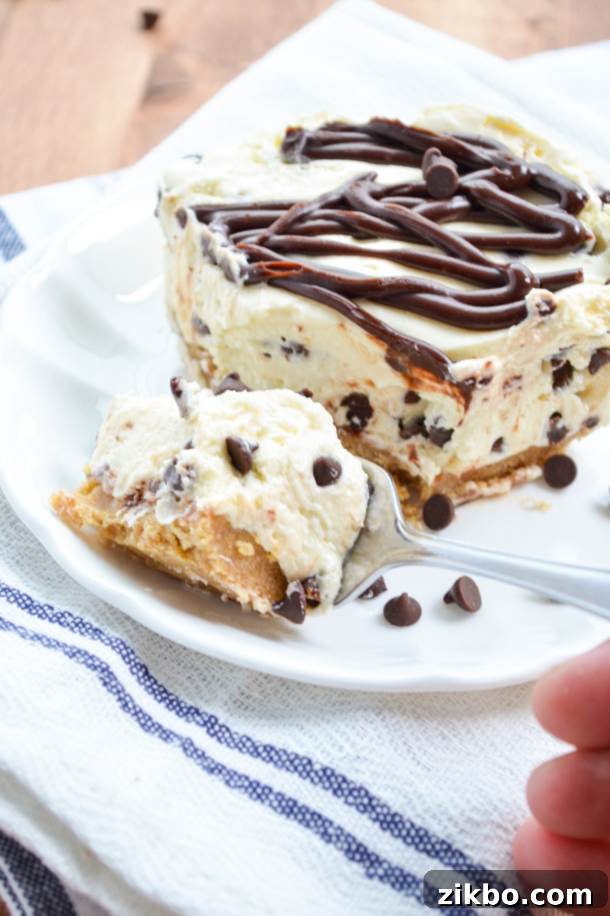 A fork taking a delicious bite out of a creamy no bake chocolate chip cheesecake.