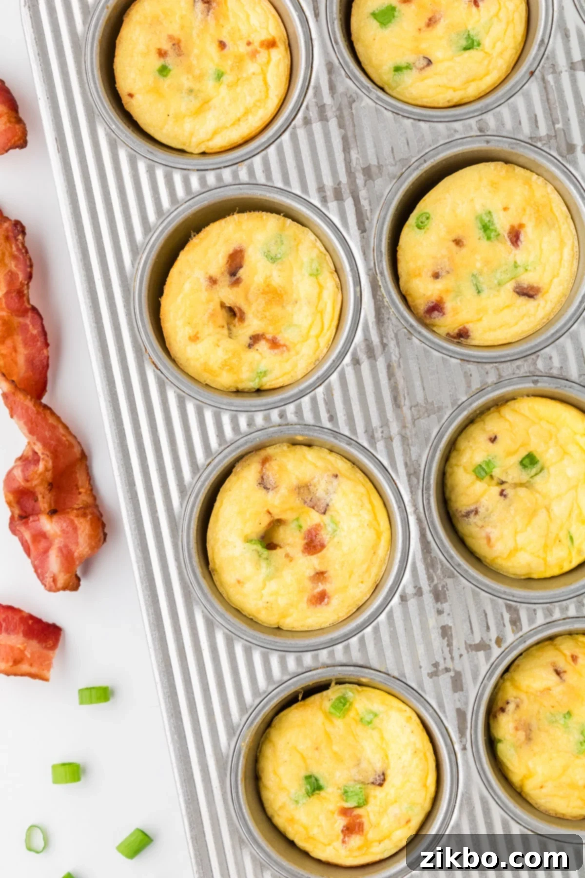 Copycat Starbucks Bacon and Gruyere Egg Bites 5 A muffin pan filled with egg bites and topped with bacon.