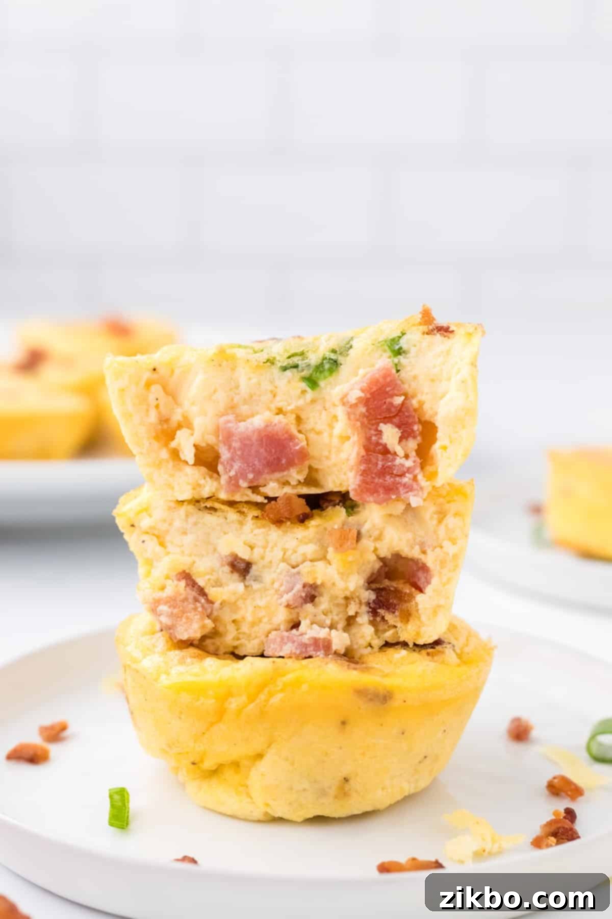 Copycat Starbucks Bacon and Gruyere Egg Bites 6 A stack of three egg cups filled with bacon and garnished with green onion.