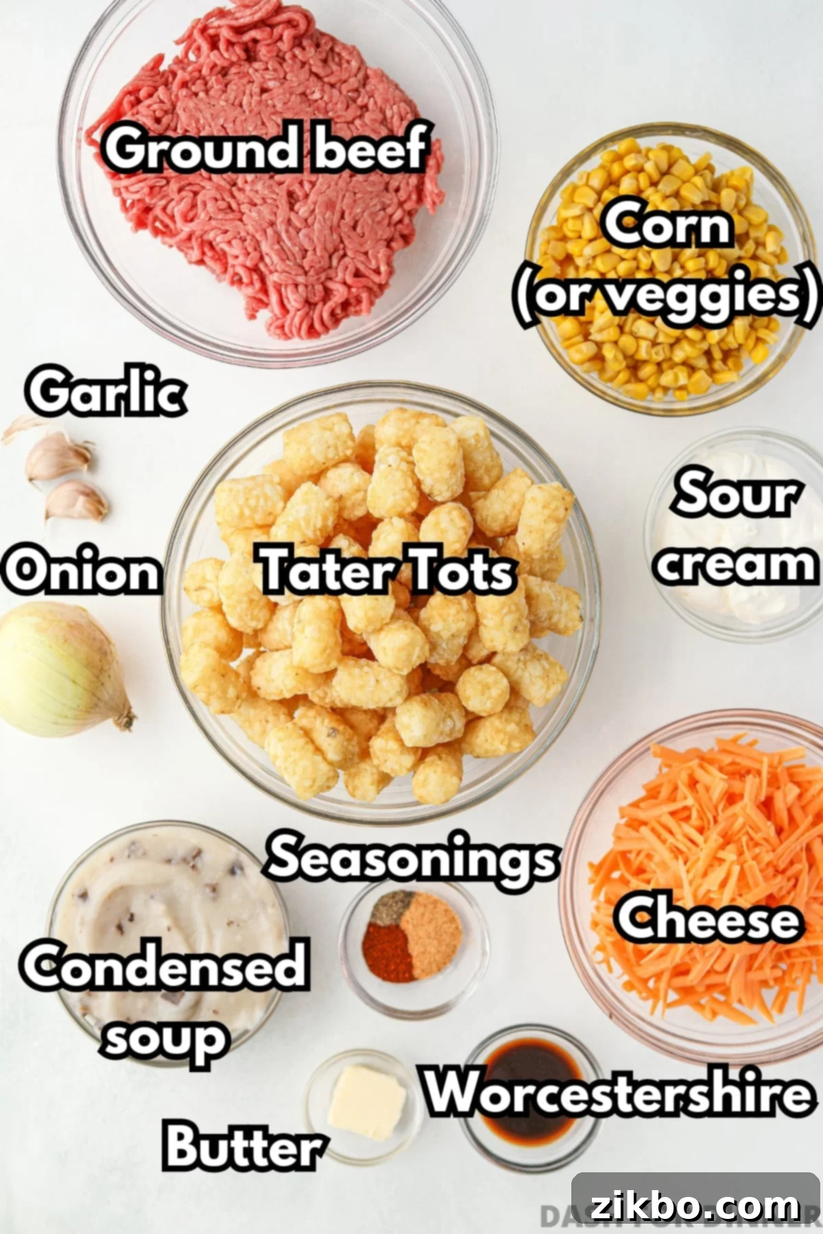 The ingredients needed to make ground beef tater tot casserole, including cheese, corn, condensed soup, and sour cream, laid out on a table.
