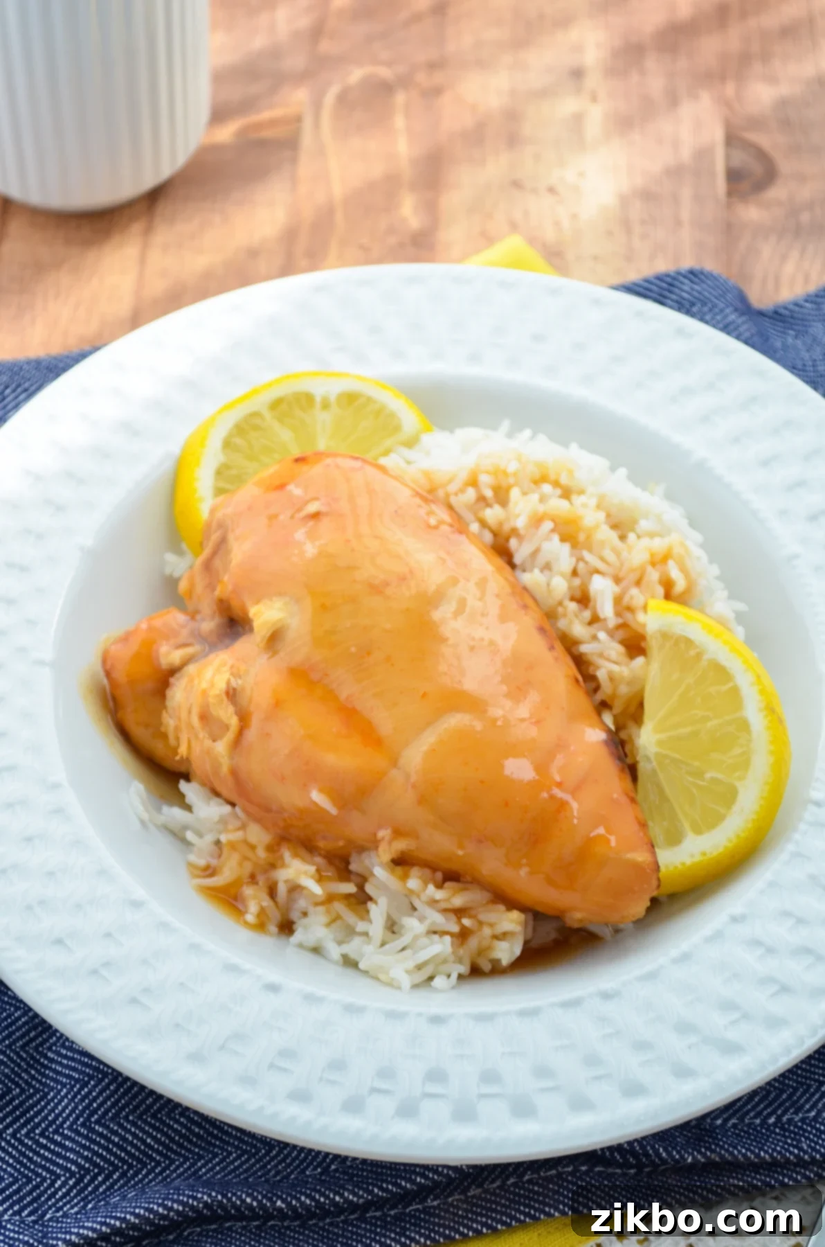 Slow cooker lemonade chicken, served over rice with lemon wedges.